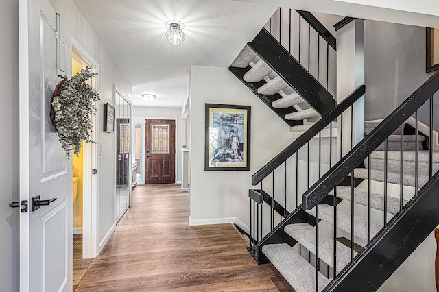 entryway with baseboards, stairway, and wood finished floors