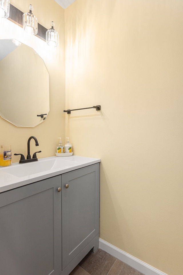 bathroom with baseboards, vanity, and wood finished floors