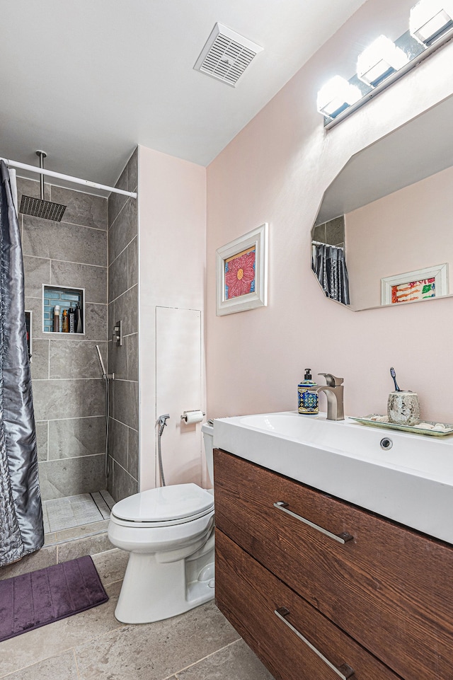 full bath with toilet, a tile shower, and vanity