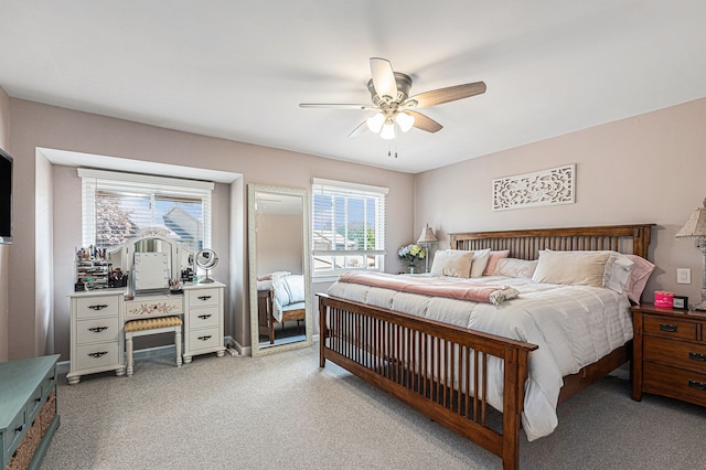 bedroom featuring light colored carpet and a ceiling fan
