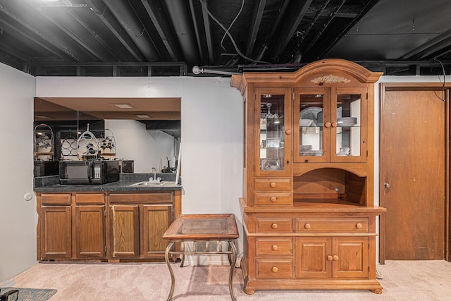 indoor wet bar with black microwave and light colored carpet