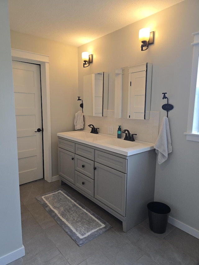 567 Angler Ave, Coldwater, MI 49036 - bathroom with double vanity, baseboards, backsplash, and tile patterned floors