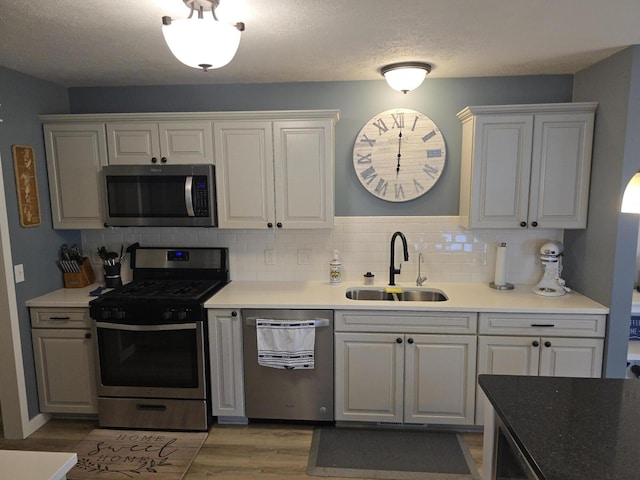 567 Angler Ave, Coldwater, MI 49036 - kitchen featuring stainless steel appliances, a sink, tasteful backsplash, light wood finished floors, and white cabinetry