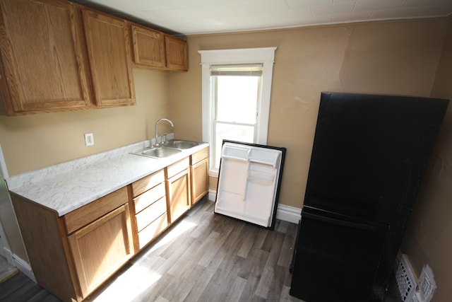 130 W Paterson St, Kalamazoo, MI 49007 - kitchen featuring a sink, wood finished floors, light countertops, and brown cabinetry