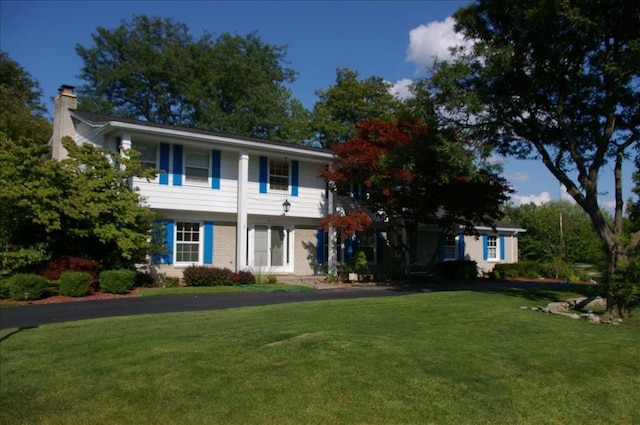 view of front of house with a front yard and a chimney