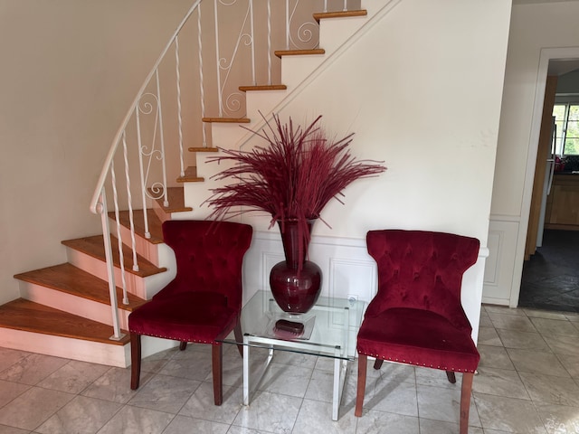 staircase with a decorative wall and wainscoting