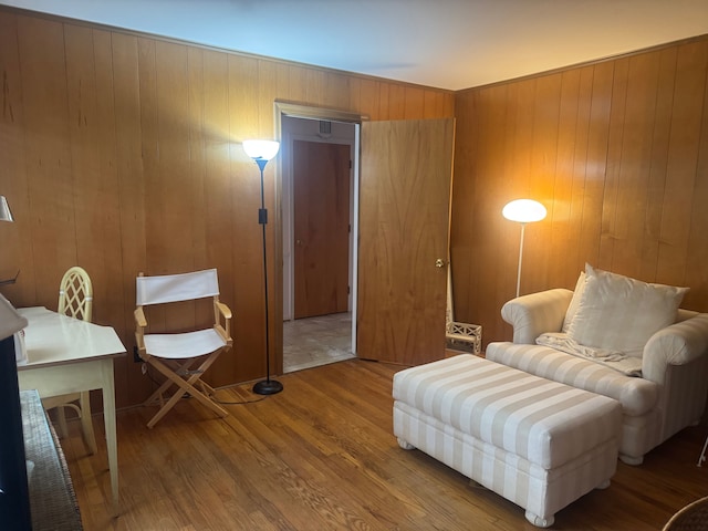 living area with wood finished floors and wood walls
