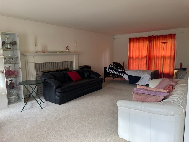 carpeted living area featuring a brick fireplace