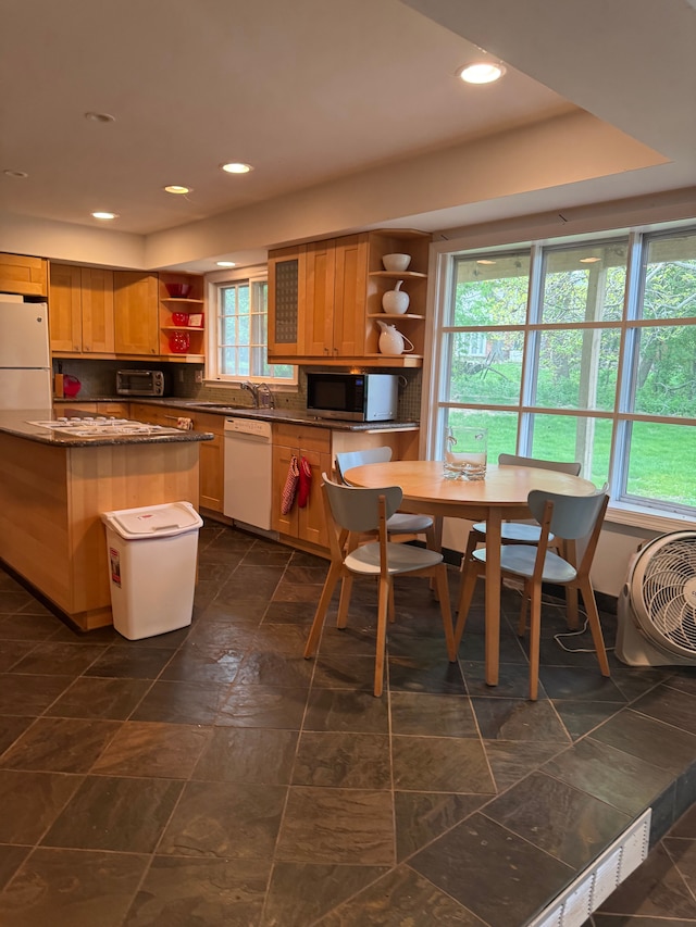 kitchen featuring open shelves, white appliances, plenty of natural light, recessed lighting, and dark stone counters