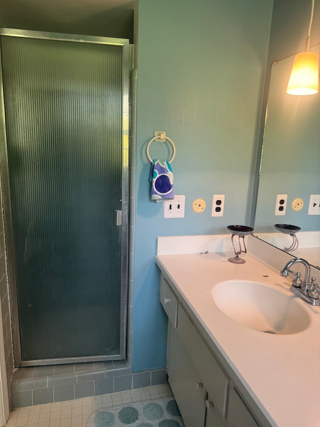 full bath with a shower stall, vanity, and tile patterned floors