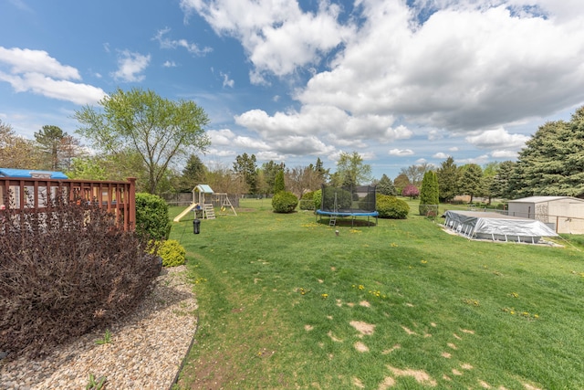 view of yard with a trampoline, a playground, and an outdoor structure