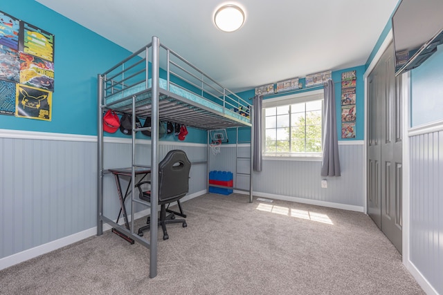bedroom featuring carpet flooring and wainscoting