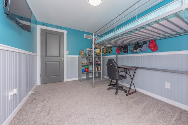 bedroom featuring carpet, wainscoting, and an office area