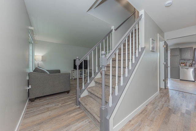 stairs featuring wood finished floors and baseboards