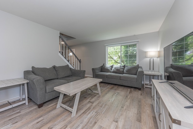 living room featuring light wood-style flooring and stairway