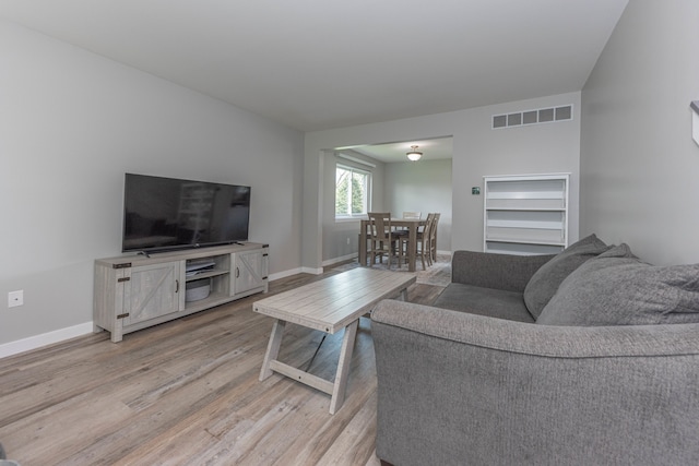living area with light wood-style floors and baseboards