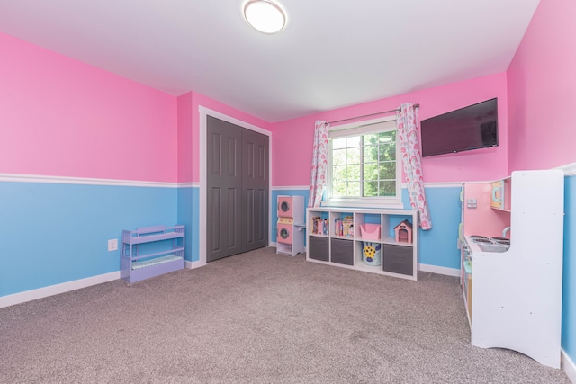 recreation room with carpet and baseboards