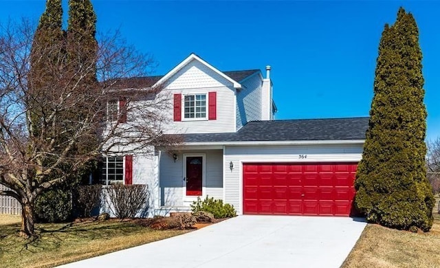 view of front of property with a garage, driveway, a chimney, and a front yard