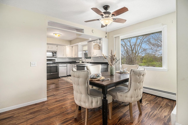 dining area with a baseboard heating unit, dark wood finished floors, ceiling fan, and baseboards