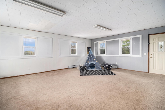 workout room with carpet, baseboard heating, and baseboards