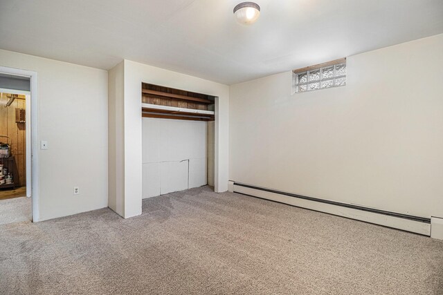 unfurnished bedroom featuring a baseboard radiator, carpet, and a closet