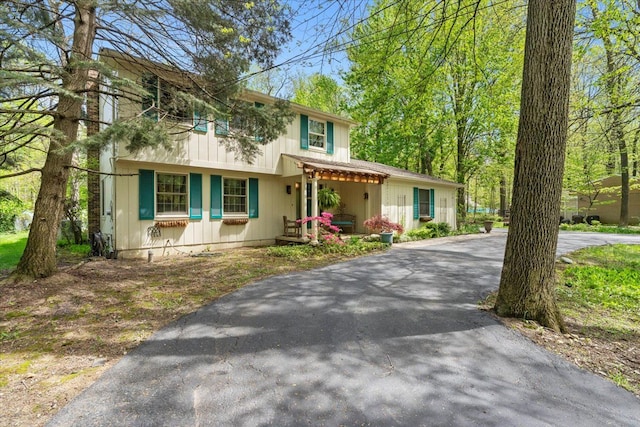 view of front of property featuring asphalt driveway and a porch