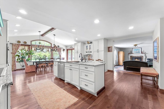 kitchen with dishwasher, a warm lit fireplace, white cabinetry, dark wood finished floors, and glass insert cabinets