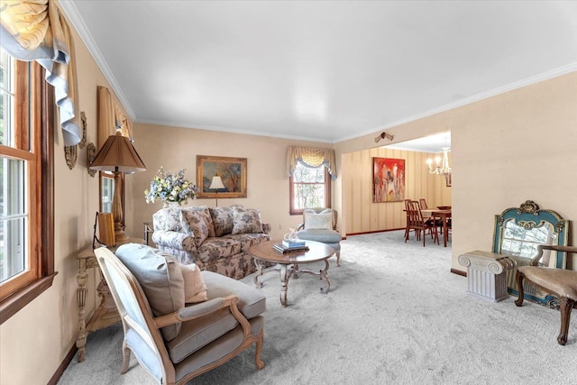 living area with ornamental molding, carpet, a chandelier, and baseboards