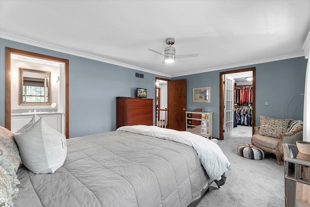 bedroom featuring carpet floors, ornamental molding, a closet, a spacious closet, and ensuite bathroom