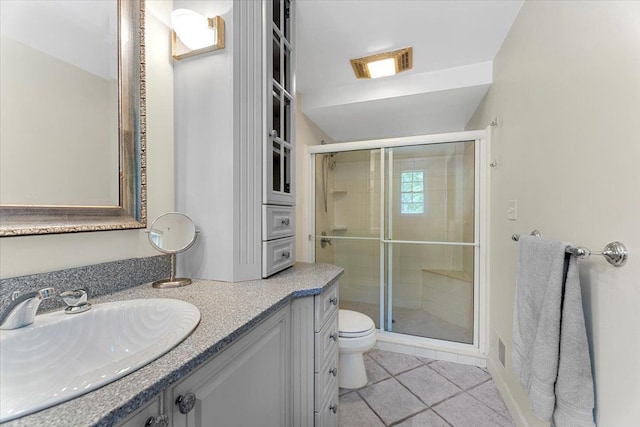 bathroom with tile patterned floors, a shower stall, toilet, and vanity