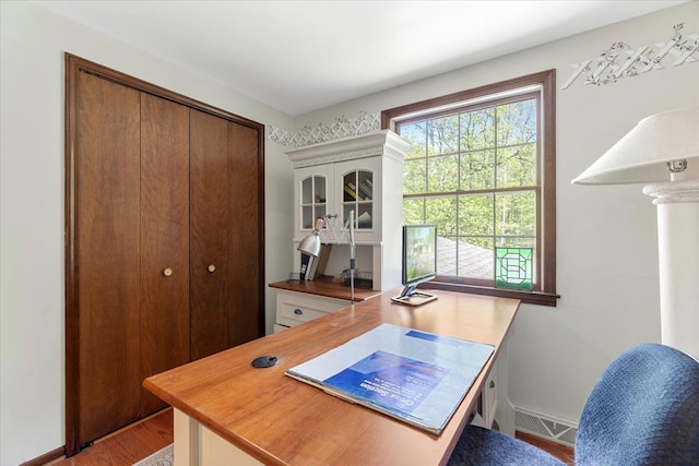 office featuring healthy amount of natural light, light wood-type flooring, and baseboards