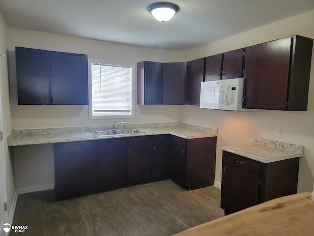 442 Beach St, Mount Morris, MI 48458 - kitchen featuring white microwave, a sink, dark wood-style flooring, light countertops, and baseboards