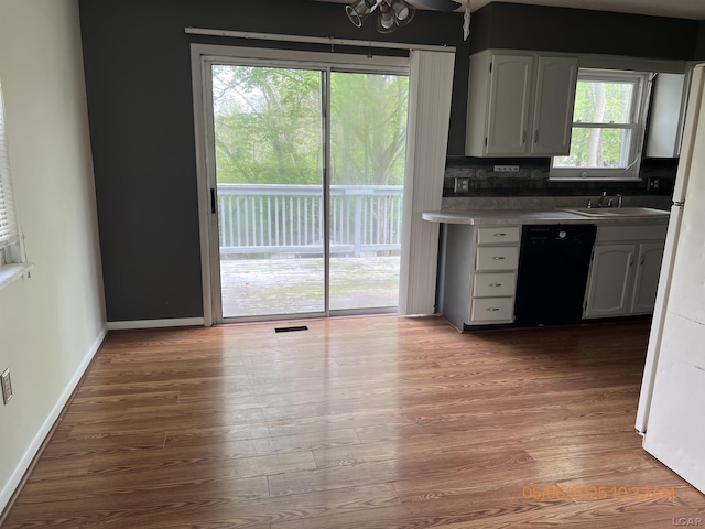 7744 Clairmont Rd, Onsted, MI 49265 - kitchen featuring dishwasher, a sink, wood finished floors, baseboards, and white cabinets