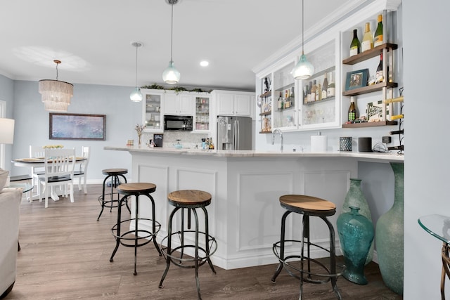1704 Cassady Place Dr, Plymouth, MI 48170 - kitchen with stainless steel fridge, black microwave, a kitchen bar, glass insert cabinets, and recessed lighting