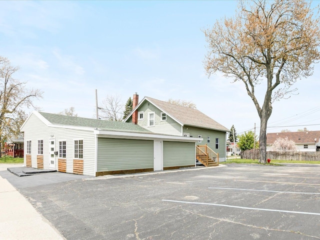 view of property exterior with a chimney and a shingled roof
