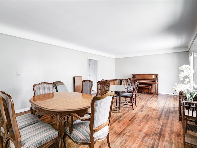dining space with light wood-style flooring and baseboards