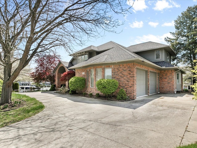 3744 Riverview Ter N, East China, MI 48054 - view of side of property featuring brick siding, concrete driveway, a garage, and roof with shingles
