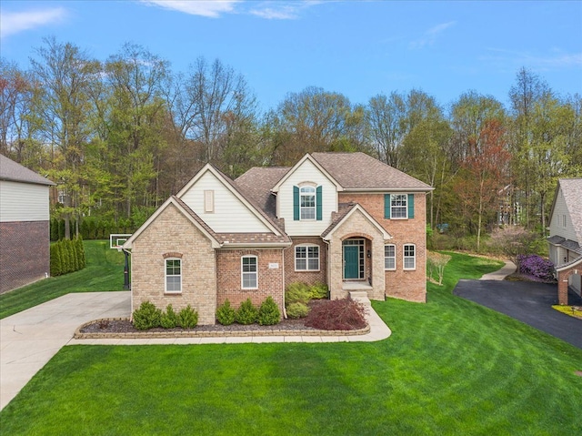5633 Golf Pointe Dr, Clarkston, MI 48348 - traditional-style home featuring a front yard, brick siding, and driveway