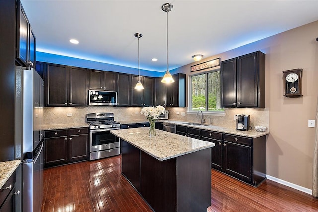 5633 Golf Pointe Dr, Clarkston, MI 48348 - kitchen featuring stainless steel appliances, a sink, a kitchen island, dark wood finished floors, and recessed lighting