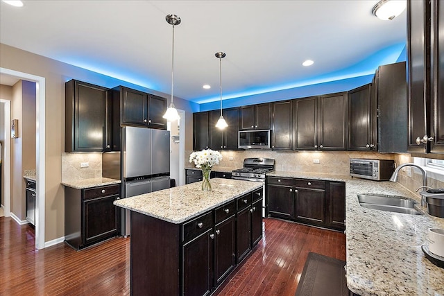 5633 Golf Pointe Dr, Clarkston, MI 48348 - kitchen with stainless steel appliances, a sink, dark wood-style floors, a center island, and recessed lighting