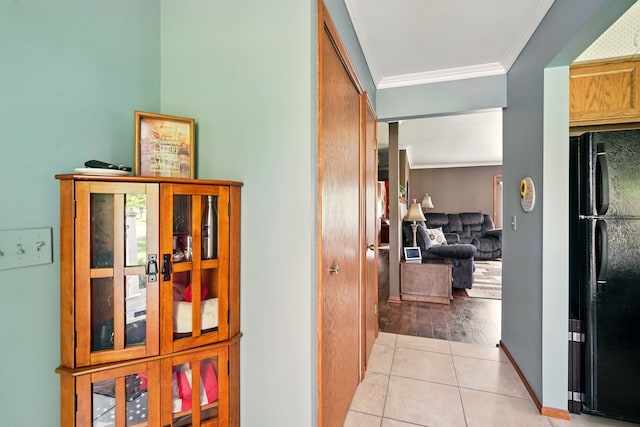 corridor featuring ornamental molding and light tile patterned floors