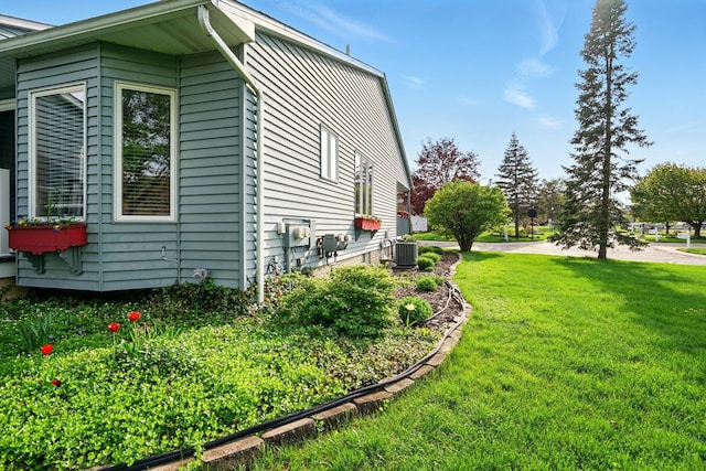 view of home's exterior featuring central air condition unit and a yard