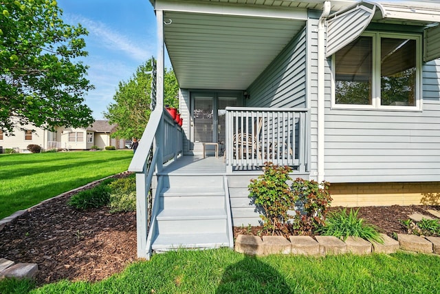 entrance to property with a yard and covered porch