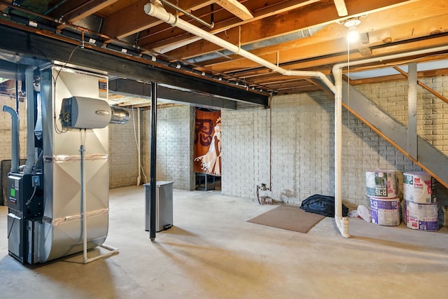 unfinished below grade area featuring brick wall and heating unit