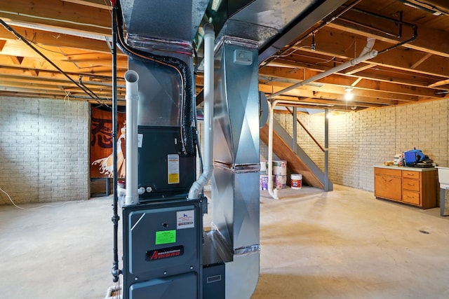 unfinished basement featuring brick wall and heating unit