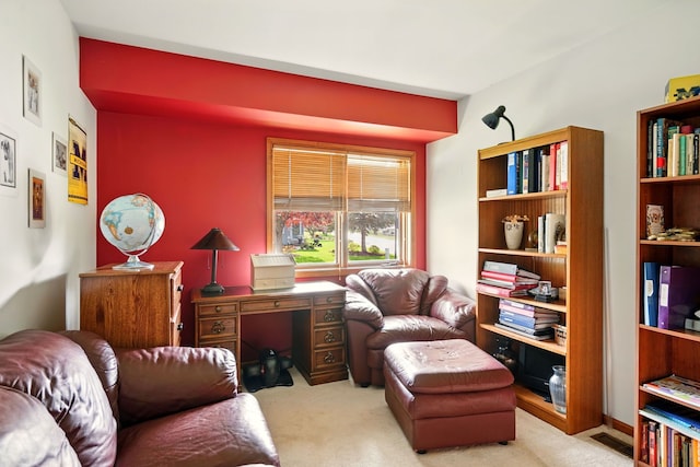 sitting room with carpet floors and an office area