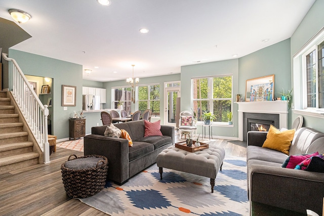 living area with healthy amount of natural light, light wood-style flooring, stairway, and recessed lighting