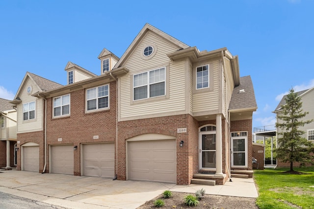 view of property featuring brick siding, an attached garage, and driveway
