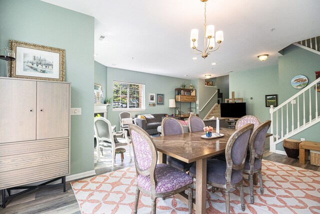dining room with stairway, wood finished floors, a chandelier, baseboards, and recessed lighting