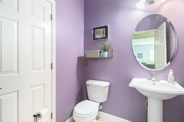 bathroom with toilet and baseboards